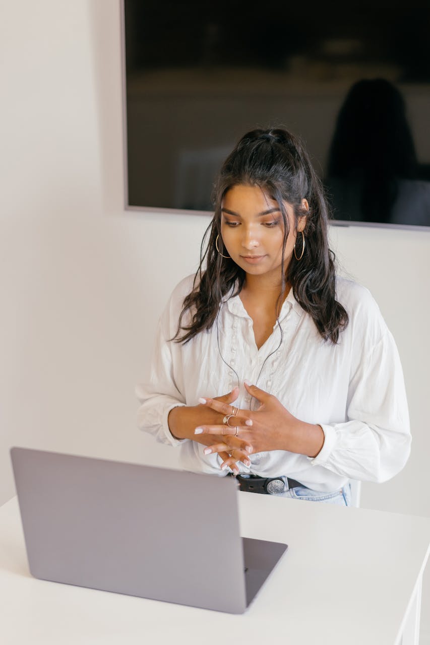 A Woman in White Dress Shirt Sitting in Front of a Laptop doing anxiety therapy online