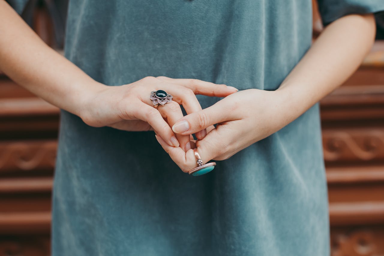 Close-up of a woman's hands adorned with ornate rings, showcasing fashion jewelry details.